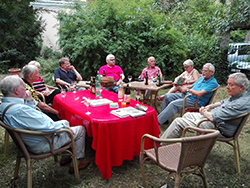 Tischrunde mit mehreren Personen in einem Garten